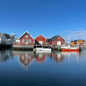 a group of houses and boats in the water at Seaside Boathouse In Veiholmen in Smøla