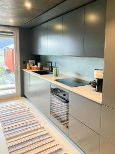 a kitchen with stainless steel appliances and a window at Seaside Boathouse In Veiholmen in Smøla