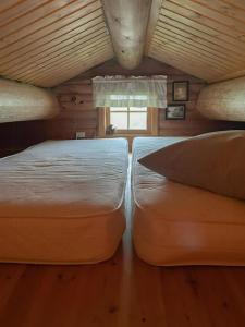 two large beds in a room with a window at Cozy, Magical Mountain Cabin With Trails in Etnedal