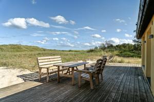 a wooden deck with a table and two chairs at Stone House's Simplicity In Jerup's Vicinity in Jerup