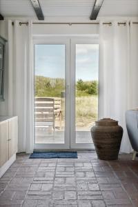 an open sliding glass door with a bench outside at Stone House's Simplicity In Jerup's Vicinity in Jerup