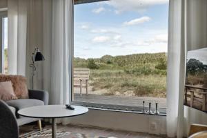 a living room with a couch and a large window at Stone House's Simplicity In Jerup's Vicinity in Jerup