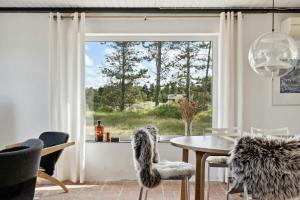 a dining room with a table and chairs and a window at Stone House's Simplicity In Jerup's Vicinity in Jerup
