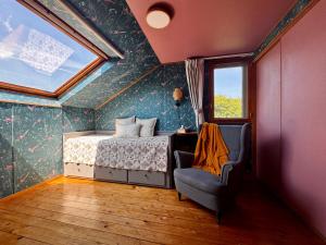 a bedroom with a bed and a window and a chair at ゲストハウス カタツムリ in Shiogama