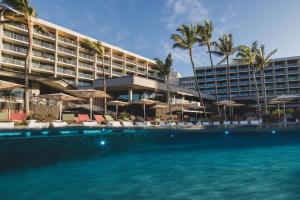 a hotel with a swimming pool with chairs and umbrellas at The Ritz-Carlton O'ahu, Turtle Bay in Kahuku