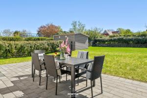 a dining table and chairs on a patio at Villa Tinnum Sylt in Tinnum