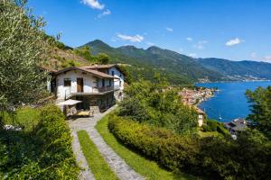 a house on a hill next to a body of water at Villa Amore in Cannobio