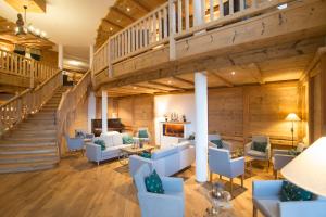 a large lobby with blue chairs and a staircase at Hotel Schlehdorn in Feldberg +193 photos