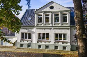 a large white house with windows and a blue roof at Ferienwohnung Edo Wiemken in Jever