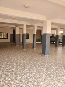 a large empty room with a patterned floor and columns at Lita résidence in Yaoundé