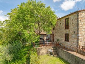 an old stone building with a tree in front of it at Countryhouse in Tuscany in Chianni