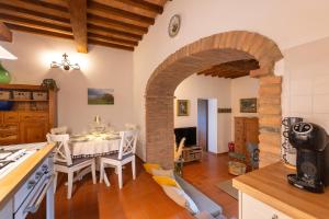 a kitchen and dining room with a table and a stone archway at Countryhouse in Tuscany in Chianni