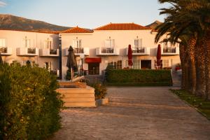 a hotel with a courtyard and palm trees at HOTEL BELLA VISTA in Mythimna