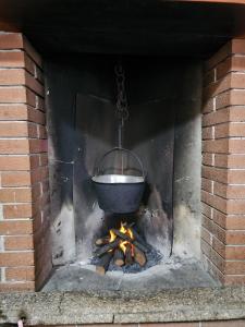 a pot over a fire in a brick oven at Eco Mountain Green House in Bienno