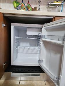 an empty refrigerator with its door open in a kitchen at Eco Mountain Green House in Bienno