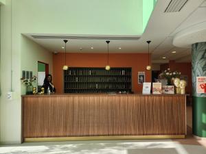 a woman standing behind a counter in a library at DOMITYS - Les Arilles in Ifs