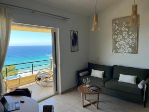 a living room with a couch and a view of the ocean at Daphne Glyfada Corfu in Glyfada