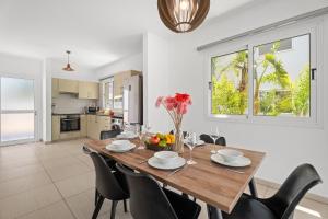 a kitchen and dining room with a wooden table and chairs at Nissini Villas in Ayia Napa