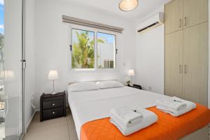 a bedroom with a large bed with two towels on it at Nissini Villas in Ayia Napa +109 photos