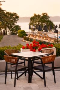 a table and chairs with flowers on a patio at HOTEL BELLA VISTA in Mythimna