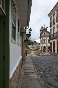 une rue pavée dans une ville avec un bâtiment dans l'établissement Casa de Rosa, à Ouro Preto