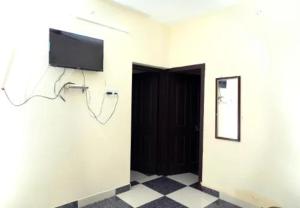 a room with a flat screen tv on a wall at Oriland Cottage in Kolli Hills +8 photos