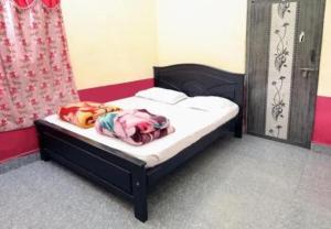a bedroom with a bed with a black frame at Oriland Cottage in Kolli Hills
