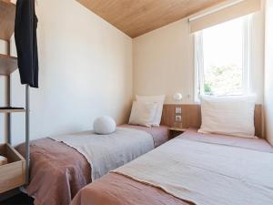 two beds in a small room with a window at Camping 4 étoiles - ccbg0ic in Saint-Éloy-les-Mines