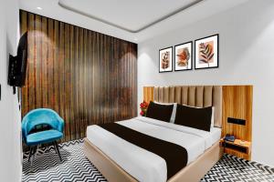a hotel room with a bed and a blue chair at Super Townhouse OAK Chandigarh Ambala Expressway Gazipur Formerly Troy Resorts and Wellness in Zirakpur