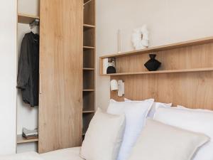 a bedroom with a bed with white pillows and a closet at Camping 4 étoiles - ccbg0ic in Saint-Éloy-les-Mines