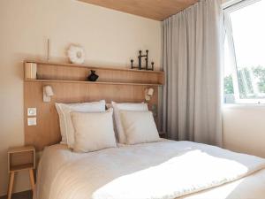 a bedroom with a white bed and a window at Camping 4 étoiles - ccbg0ic in Saint-Éloy-les-Mines
