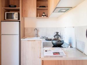 a kitchen with a white refrigerator and a bowl on the counter at Camping 4 étoiles - ccbg0ic in Saint-Éloy-les-Mines +8 photos