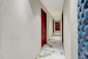 a corridor with a red door and white walls at Super Townhouse OAK Chandigarh Ambala Expressway Gazipur Formerly Troy Resorts and Wellness in Zirakpur