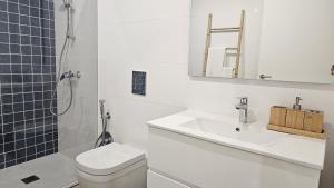 a white bathroom with a toilet and a sink at Costa Nova Azul in Gafanha da Encarnação +15 photos