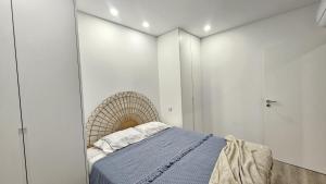 a bedroom with a bed and white walls at Costa Nova Azul in Gafanha da Encarnação
