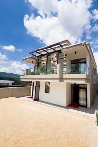 a large white house with a roof at Plenty Residence by Splendid Hotel, Retreat & Group Stay Near Kigali in Runda