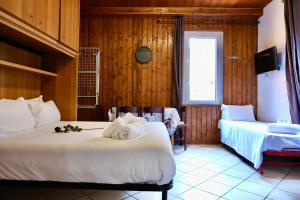 a hotel room with two beds and a window at The Courtyard Retreat in Brunate
