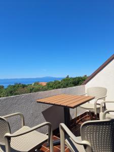 a patio with a wooden table and chairs on a roof at Apartmani Belobrk Potocnica Pag in Potocnica +61 photos
