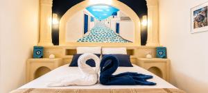 a bedroom with a bed with two swans on it at Le secret de Santorin in Martigues