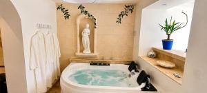 a bathroom with a bath tub with a statue in it at Le secret de Santorin in Martigues +10 photos