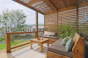 a screened in porch with a couch and a table at Chalet 4 étoiles - Piscine - ccbg00h in Celles-sur-Plaine