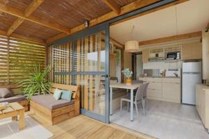 a living room with a table and a kitchen at Chalet 4 étoiles - Piscine - ccbg00h in Celles-sur-Plaine