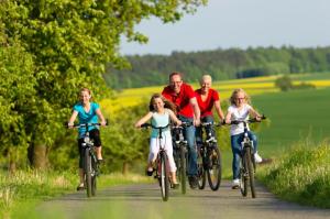 a group of people riding bikes down a road at Chalet 4 étoiles - Piscine - ccbg00h in Celles-sur-Plaine