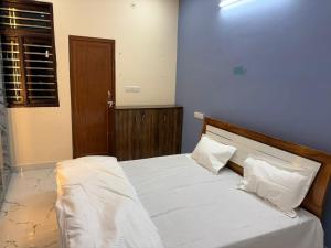a bedroom with a bed with white sheets and pillows at Divine House in Lucknow