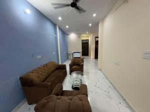 a living room with two couches and a ceiling fan at Divine House in Lucknow