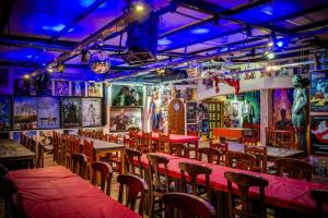 a restaurant with tables and chairs and purple lights at Lemon Tree Hostel in Vistalba