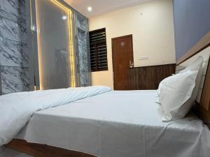 a bedroom with a large white bed with white sheets at Divine House in Lucknow