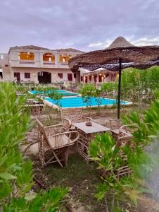 a resort with a table and chairs and a swimming pool at King Siwa in Siwa