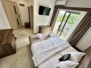 a hotel room with a bed and a large window at WEST GATE free parking & wi-fi in Sutomore