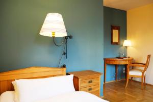 a bedroom with a bed and a desk and a lamp at Gästehaus im Flüsterbogen in Görlitz